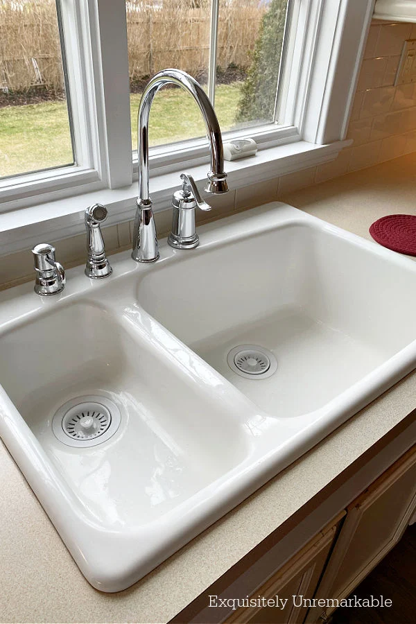 White drop in double Kohler cast iron kitchen sink in a country kitchen