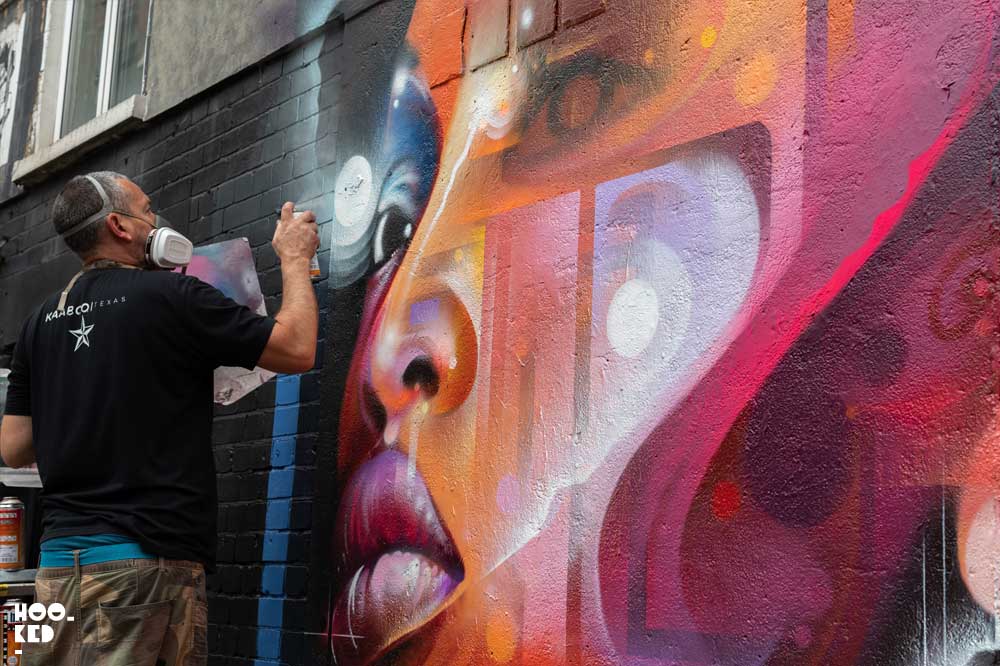 Brick Lane Street Art - Artist Mr Cenz at work on a mural on Bacon Street, London