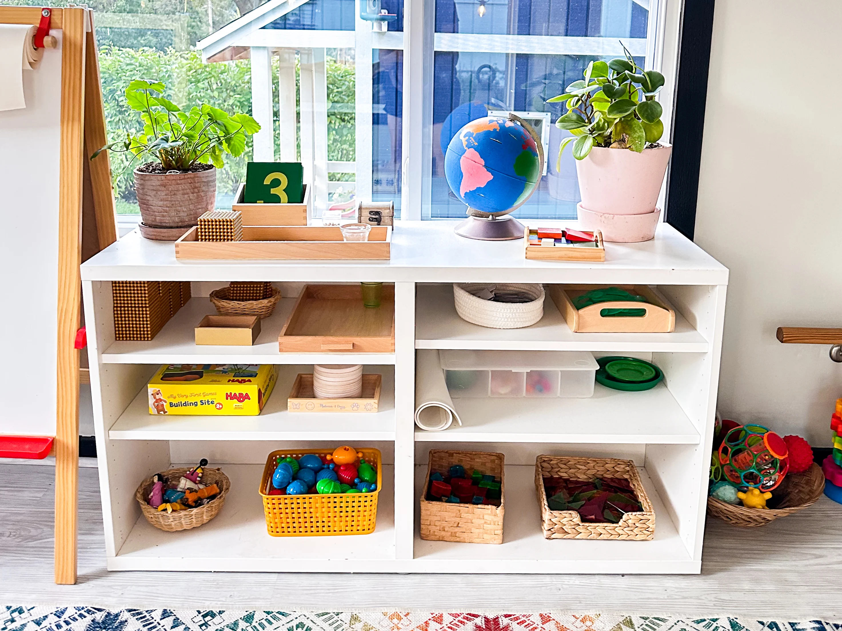 A Montessori playroom shelf with learning activities and traditional Montessori academic toys