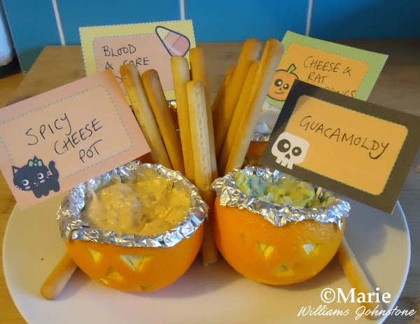 4 dips served in pumpkin style carved oranges with breadsticks