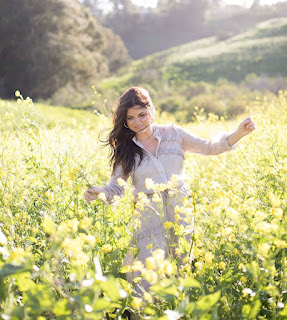 Tiffani Thiessen posing for picture in the field