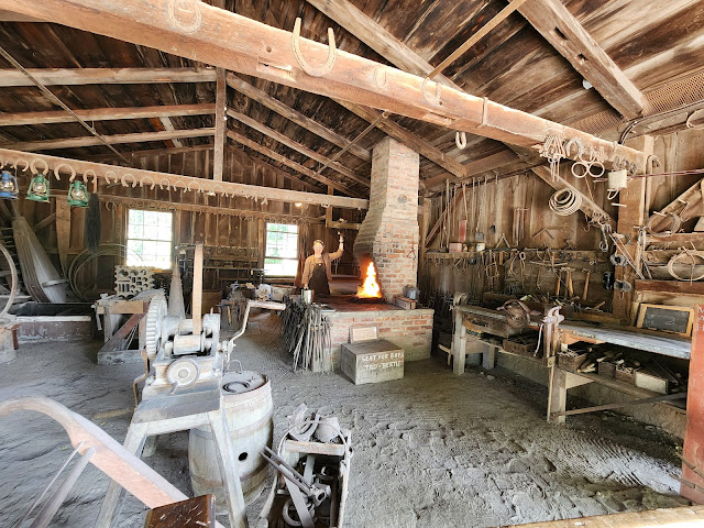 Blacksmith operating the bellows to the forge