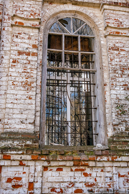 Пластиковое окно за решеткой заброшенной церкви