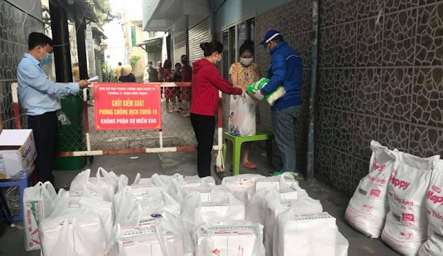 Lãnh đạo Phường 21 tặng quà các hộ dân ở khu phong tỏa kiểm soát dịch Covid-19. (Ảnh Hoàng Nam)