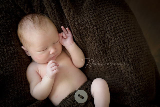 newborn baby boy on brown blanket