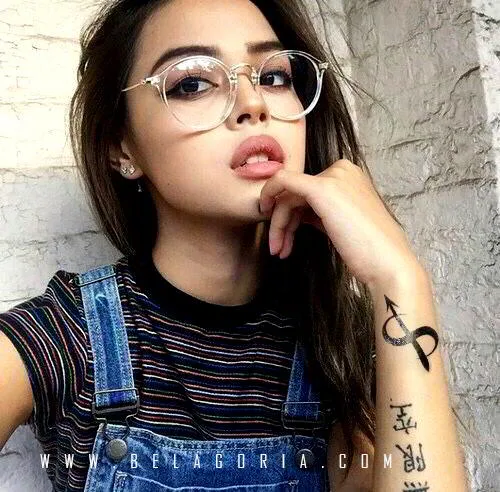 Preciosa imagen de una chica con gafitas tatuada con sagitario