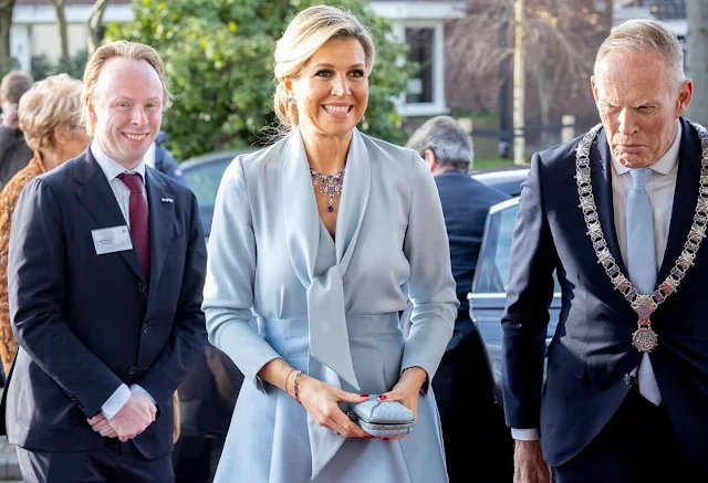 Queen Maxima wore a sky blue silk bow blouse and light blue silk satin midi skirt by Natan