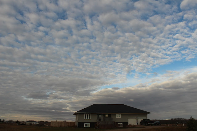 fluffy clouds over house