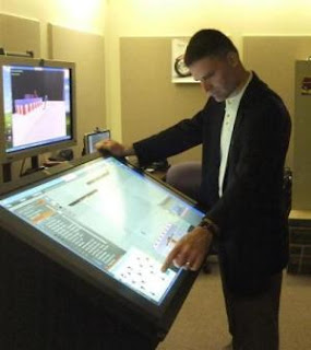 An instructor uses a prototype touch kiosk to move and align 3-D modeled assets with the Site Security Planning Tool. (Credit: United States Secret Service)