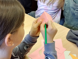 Dziecko maluje filiżankę trzymaną w dłoni.