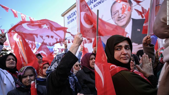 AKP supporters wave Turkish flags at a campaign rally in Kasımpaşa