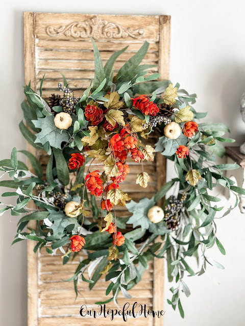 casual and elegant fall eucalyptus leaf wreath with hops stems and white pumpkin picks