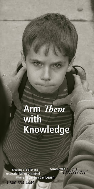 An anxious child looks an aggressor in the eye while they have their hands forcefully on the child's shoulders