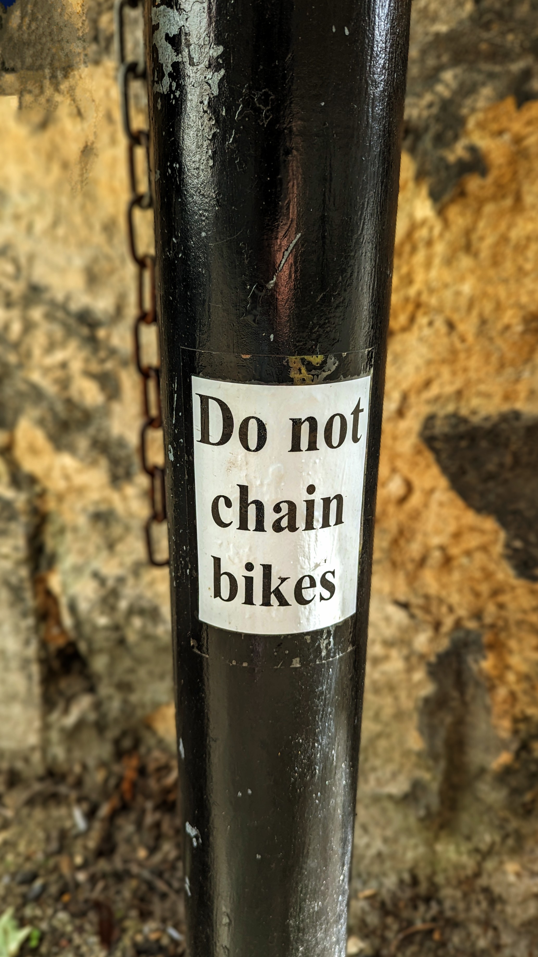 "Do Not Chain Bikes" sign on a black metal pole