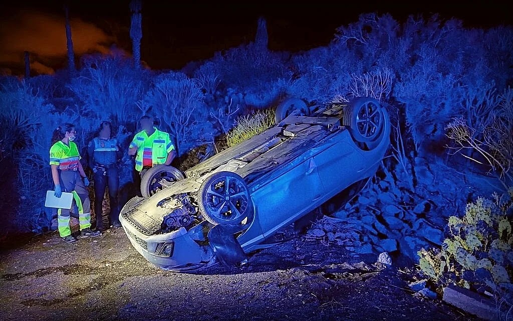 Agentes y operarios de ambulancia junto al vehículo accidentado (Foto: Policía Local de Canarias Blog).