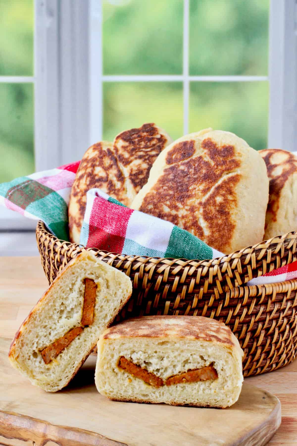 Bolos do Caco with Chouriço in a basket with one roll in front.