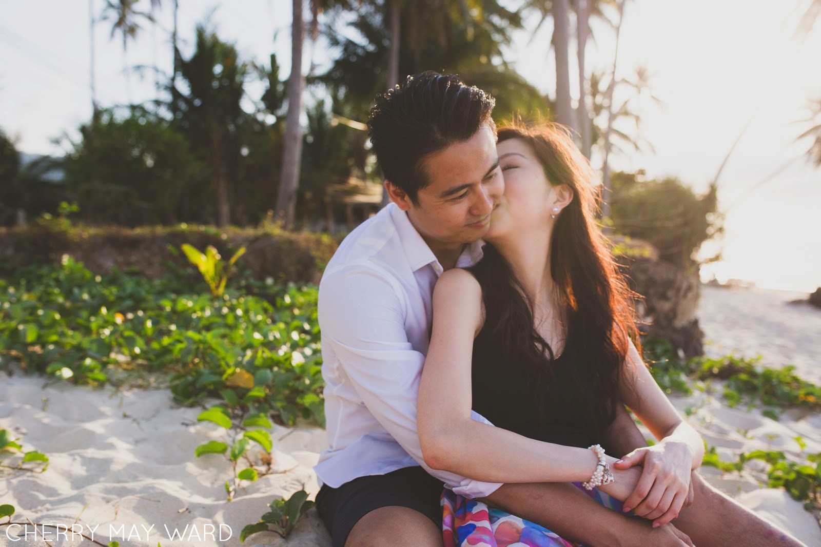 Couple sitting on the beach, Ban Tai Beach, Koh Samui, young couple in love, kissing cheek