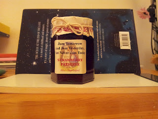 Real pot of jam themed around Alice through the looking glass with the quote about jam tomorrow and yesterday on it