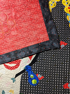 The dark grey facing on the Clara collage quilt hides all binding to the back.