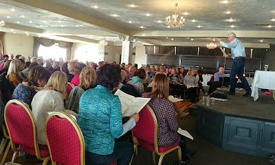 Seated choir members practising a work in the ballroom of the Armada Hotel, Spanish Point.