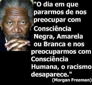 Imagem quadrada em fundo preto; no canto superior esquerdo, foto em close de Morgan Freeman, ator americano, nascido em Memphis, Tennessee, com 79 anos de idade. O rosto ovalado e anguloso emoldurado por cabelos curtos bem frisados grisalhos, no mesmo tom do bigode e cavanhaque é salpicado por pintas escuras nas bochechas e outras menos visíveis espalhadas pela pele negra. Morgan mostra semblante sério, testa franzida em três profundas rugas, olhos médios bem escuros focados em nossa direção, nariz largo e os lábios parcialmente encobertos pelas mãos entrelaçadas à frente. Ao lado direito, texto em letras caixa alta brancas: “O dia em que pararmos de nos preocupar com Consciência Negra, Amarela ou Branca e nos preocuparmos com Consciência Humana, o racismo desaparece.” (Morgan Freeman)