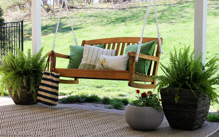 Spring covered patio refresh with porch swing, outdoor rug and potted ferns