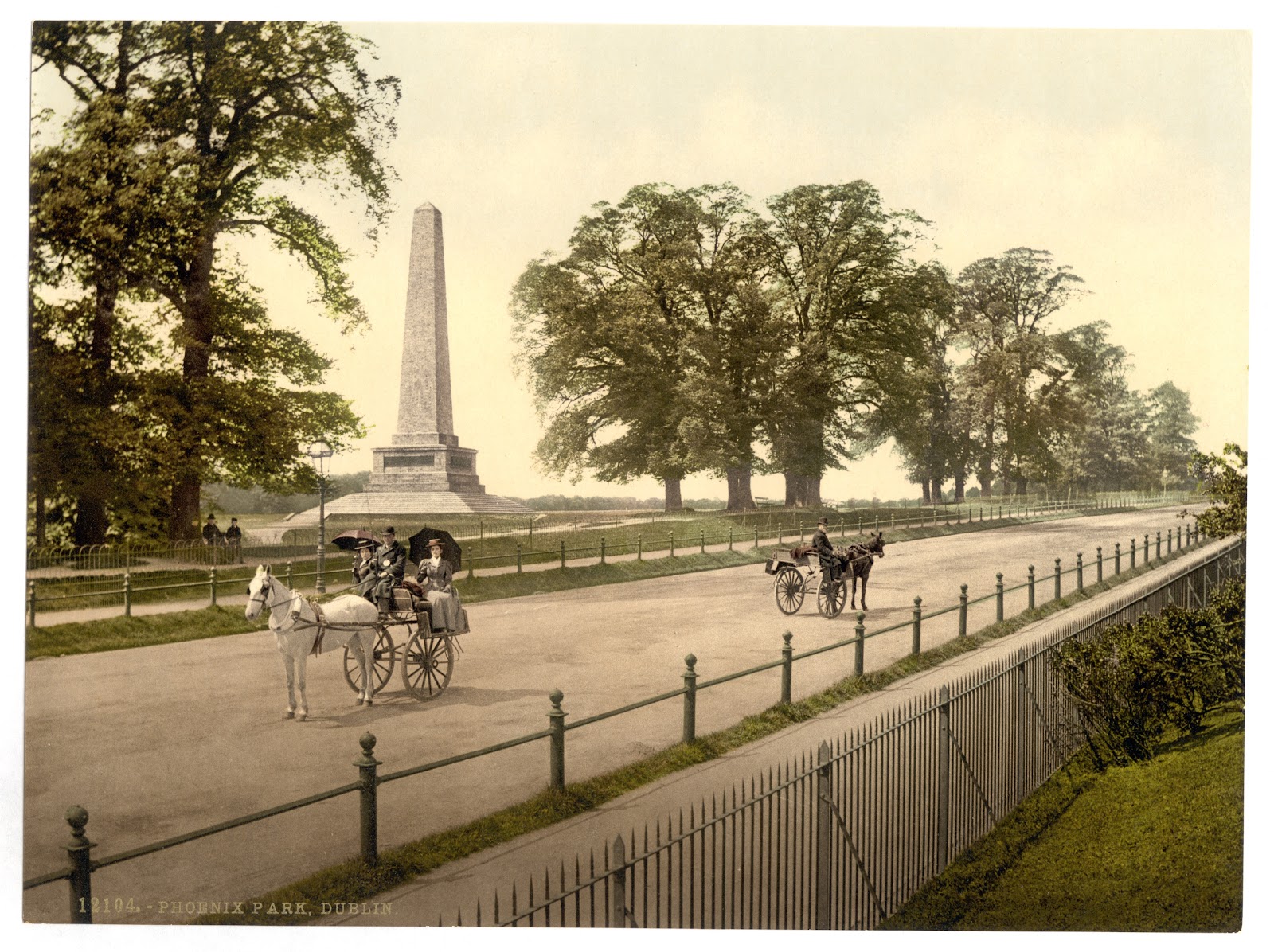 ダブリン市のフェニックスパークのウェリントン記念碑が見える道に二台の二輪馬車が停まっている