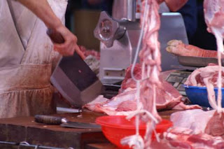 Image of a butcher in Hong Kong with a big cleaver.