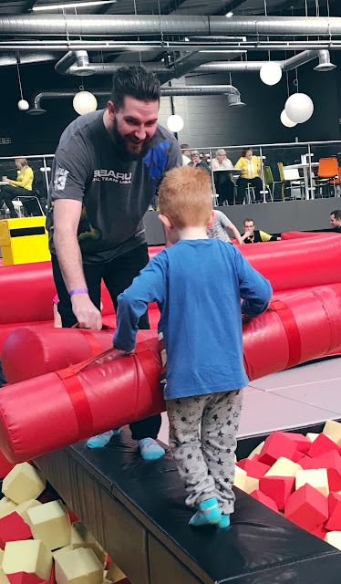 Daddy and little boy on a balance beam with gladiator style poles