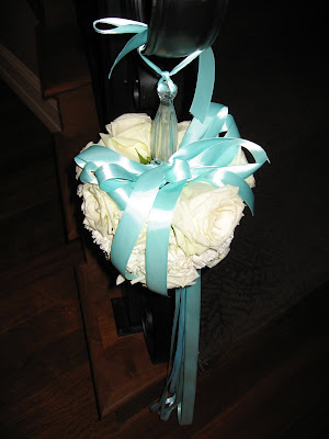 topiary at the end of the staircases roses accented with turquoise ribbon