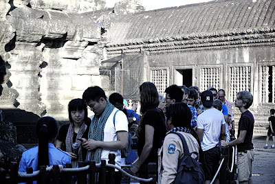 A long queue of tourists at the Angkor Wat tallest ancient building waiting to climb up for a visit