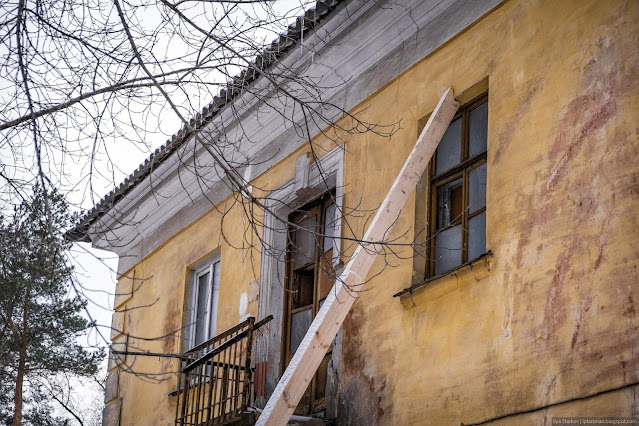 Балка подпирает стену дома, упираясь в окно