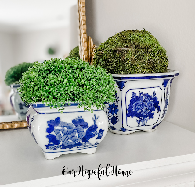 chinoiserie cache pots filled with moss balls and faux plants