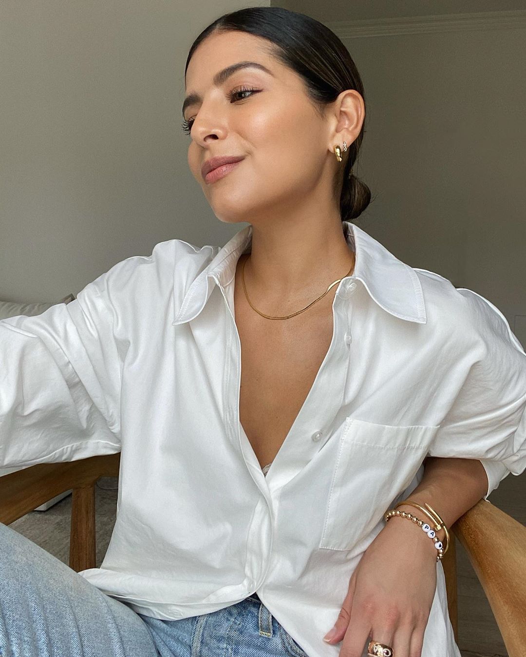 Easy Classic Fall Oufit Combo — Pam Arias in gold hoop earrings, delicate gold necklace, white button-down shirt and jeans