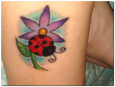 Comments: Flower, ladybug, and name on a hip. Flower and ladybug tattoo.