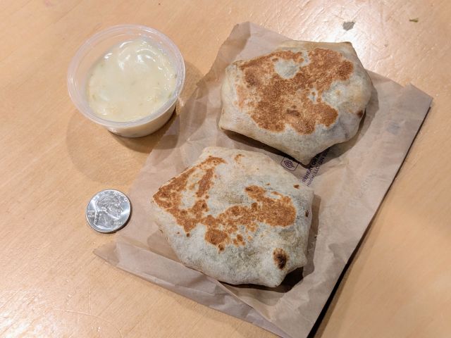 Taco Bell's Steak & Queso Crunchwrap Sliders next to a quarter.