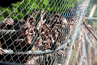 Os zumbis tentam derrubar a cerca da prisão na 4 temporada de Walking Dead