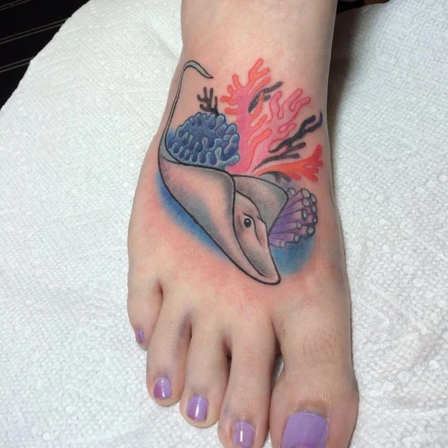 exquisito tatuaje de mantarraya en el pie de una chica