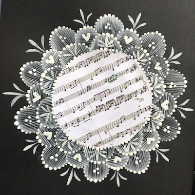 A circle of music paper framed by hand painted lace like designs from You Can Folk it 