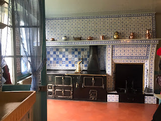  foto da cozinha com fogão à lenha e paredes azulejadas em tons azul e branco  