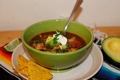 Bowl of chicken taco soup with a spoon.