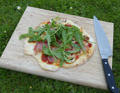 Pizza mit Champignons, Schinken und Rucola