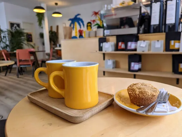 coffee in yellow mugs and pear cardamom cake at Tigershark in The Hague