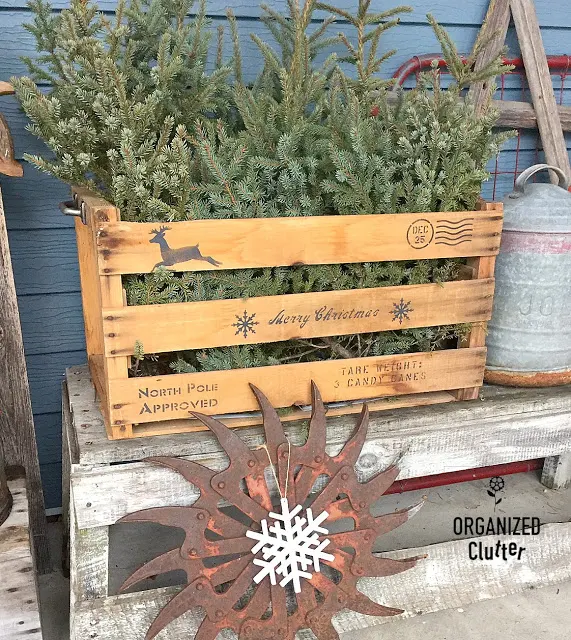 Crate with spruce tips stenciled with Christmas shipping stamps