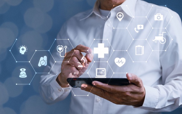 Man holding a tablet with healthcare focused icons floating in the air