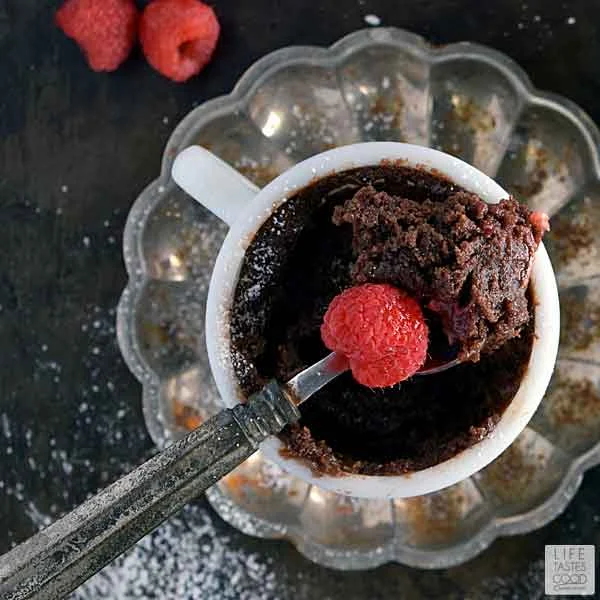 White Mug with Gooey Chocolate Mug Cake on Rustic Silver Fluted Saucer, Topped with Fresh Raspberries