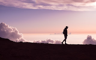 silhouette of man walking on a hill and thinking