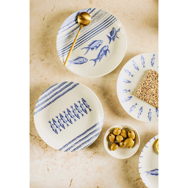 blue and white plates with fish and olives