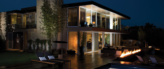 Picture of modern mansion at night with outdoor fireplace on the terrace