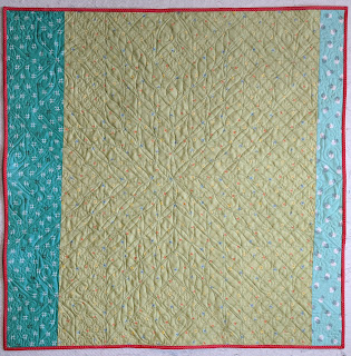 Light green print with aqua prints to each side create the quilt back